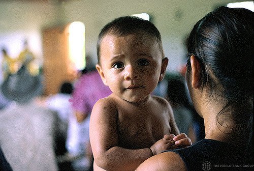 A mother with her child at a workshop for farmers in Vila Da Canoas, Brazil. Credit: World \Bank Group